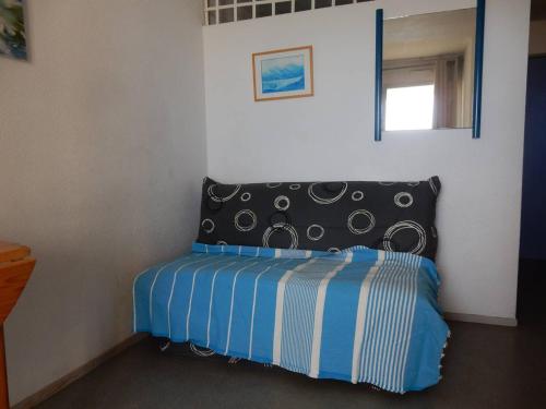 a bedroom with a bed with a black and blue comforter at Appartement Canet-Plage, 2 pièces, 5 personnes - FR-1-750-35 in Canet-en-Roussillon