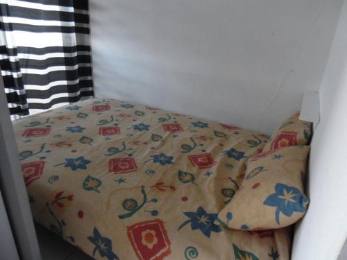 - un petit lit avec une couverture et des oreillers dans l'établissement Studio Canet-Plage, 1 pièce, 4 personnes - FR-1-750-47, à Canet