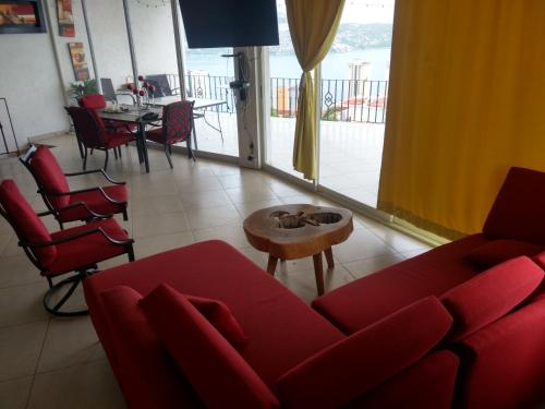 sala de estar con sofá rojo y mesa en Campanario07 en Acapulco