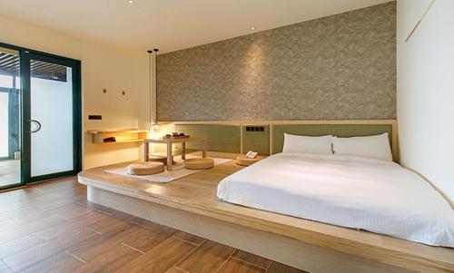 een slaapkamer met een groot bed en een groot raam bij Yanmin Hot Spring Resort in Taipei