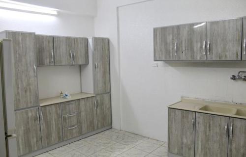 a kitchen with wooden cabinets and a sink at شقه النزهه مكونه من غرفتين وصاله ودورتين مياه وغرفه طعام in Medina