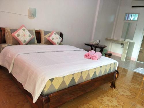 Un dormitorio con una cama con arcos rosados. en Alongkon Mansion, en Sakon Nakhon