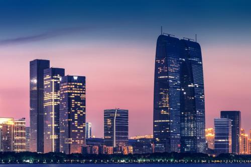 een skyline van de stad 's nachts met hoge gebouwen bij W Suzhou - Jinji Lake in Suzhou