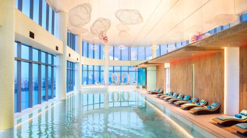 a swimming pool in a building with windows at W Suzhou - Jinji Lake in Suzhou