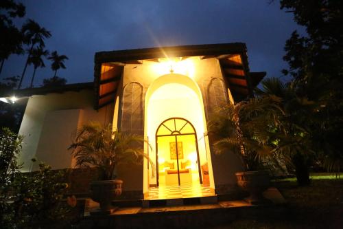 a small house with a yellow door at night at Ella Planters Bungalow in Ella
