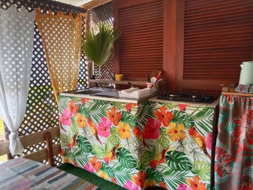 une cuisine avec un comptoir à motifs floraux dans l'établissement Chalet chez Téra'i, à Avatoru