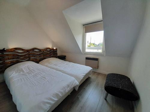une chambre avec deux lits et une fenêtre dans l'établissement Maison cosy 3 pièces avec terrasse à 800m de la plage - Wifi, lave-vaisselle, parking public - FR-1-477-238, à La Trinité-sur-Mer