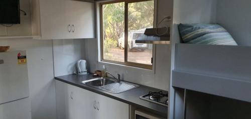 a small kitchen with a sink and a window at Gracetown Caravan Park in Gracetown