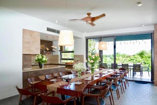 een grote eetkamer met een lange tafel en stoelen bij Nam Casa Sân Golf Tam Đảo Venuestay in Tam Ðảo