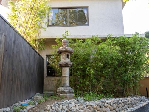 a stone pillar in front of a house at Tabist Nanki Shirahama Ryokan Mantei in Shirahama