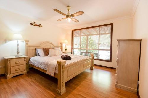 a bedroom with a bed and a ceiling fan at Camellia Cottage - Country Rustic Charm Close to Forest and Town in Margaret River Town