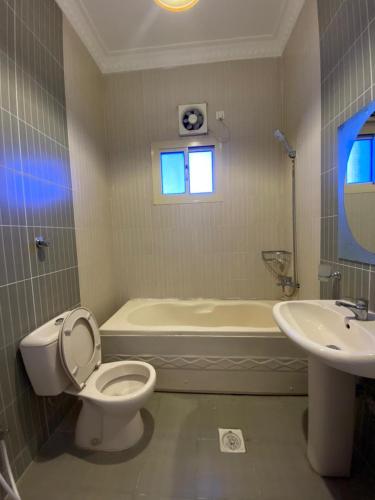 a bathroom with a toilet and a tub and a sink at منتجع أرين للوحدات السكنية in Al Hada