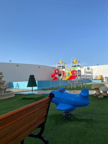 a blue dog on a bench next to a playground at شقق ارين المصيف in Al Hada