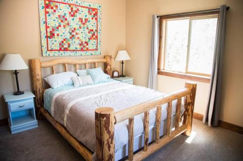 a bedroom with a wooden bed and a window at The Maple Retreat in Garden City