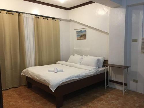 um quarto com uma cama com uma mesa e cortinas em Casa de Primera B31 beach front station 3 em Boracay