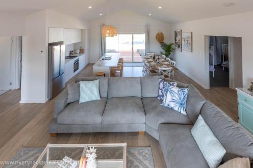 a living room with a gray couch and a kitchen at Pina Colada Shack-40 Marina Way in Mannum