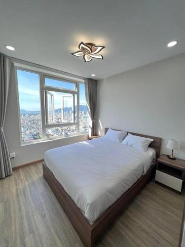 a bedroom with a large bed and a large window at ChouChou Apartment in Danang