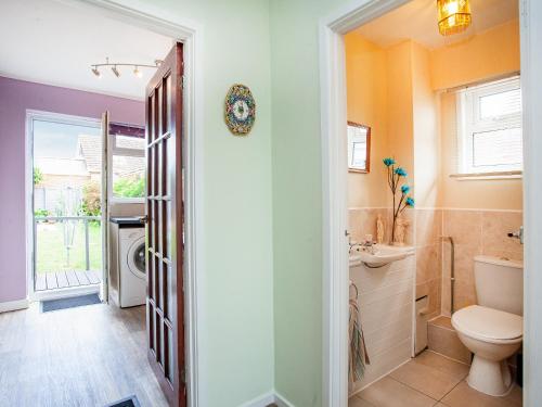 a bathroom with a toilet and a sink at Hookhills Holiday Home in Goodrington