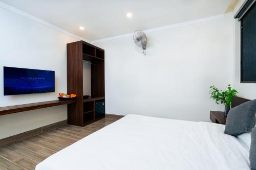 a bedroom with a white bed and a flat screen tv at PLEIKU HIGHLANDS BOUTIQUE HOTEL in Plei Brel (2)