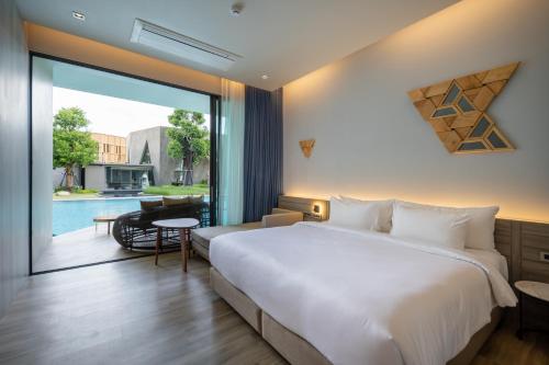 a bedroom with a large bed and a view of a pool at The Signature Hotel Airport in Hat Yai