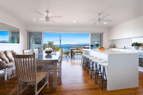 a kitchen and dining room with a view of the ocean at Spirit of Gerroa in Gerroa