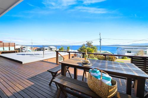 a wooden deck with a wooden table and chairs on it at Spirit of Gerroa in Gerroa