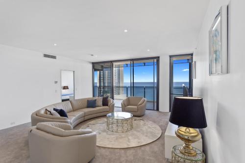 a living room with couches and a table with a lamp at Holiday Holiday Circle On Cavill Apartments in Gold Coast