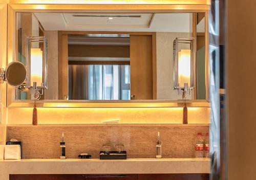 a bathroom with a large mirror and a sink at Sheraton Wuxi Binhu Hotel in Wuxi