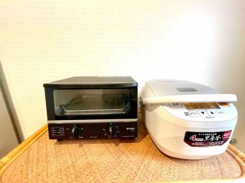 a microwave and a toaster oven sitting on a table at 一棟貸別荘 Oceanic Villa Minamiizu!17名まで!弓ヶ浜海水浴場まで徒歩6分 in Minamiizu