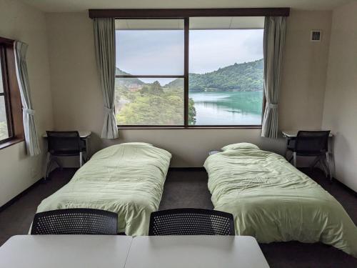 two beds in a room with a large window at H,U,B Unzen - Vacation STAY 78660v in Unzen