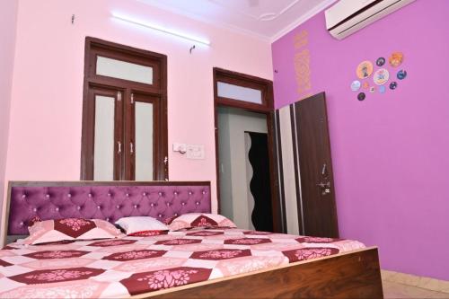 a bedroom with a bed with pink and purple walls at Manu Villa A Royal Stay in Jaipur