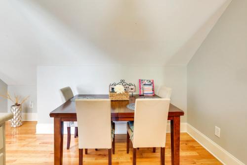 a dining room with a wooden table and white chairs at 4 Mi to Dtwn Simplistic Summerville Studio in Summerville