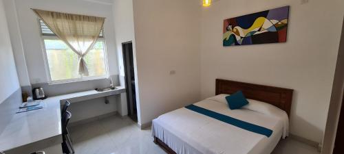 una piccola camera con letto e finestra di Ceylon Lodge - Airport Transit Hotel & Hostel a Negombo