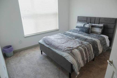1 cama en un dormitorio con ventana en Spacious Stay, en Fort Worth