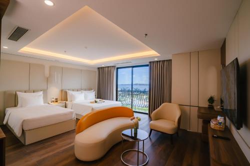 um quarto de hotel com duas camas e um sofá em Danitel Halong em Ha Long