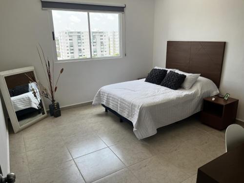 a bedroom with a bed and a mirror and a window at Departamento GaFe in Cancún