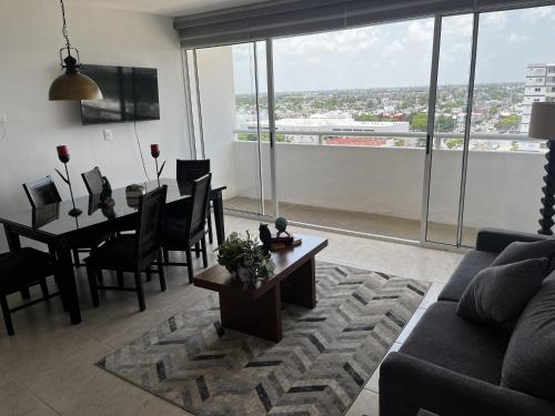 a living room with a couch and a table with a view at Departamento GaFe in Cancún