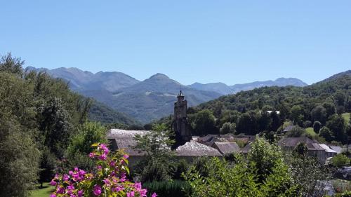 a small village with a church and mountains in the background at La maison du sabotier in Audressein