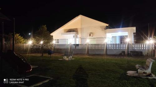 una casa con luces en el patio por la noche en Murni Inn Pulasan, en Guar Chempedak