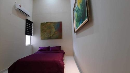 1 dormitorio con 1 cama y una pintura en la pared en Murni Inn Pulasan, en Guar Chempedak