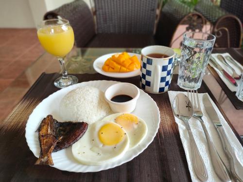 邦勞的住宿－DMC1 Residence Panglao，桌上放一盘鸡蛋、培根和咖啡