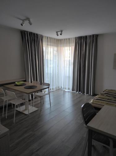 a living room with a table and chairs and curtains at Private Baltic Cliff Niechorze obok Latarni Morskiej in Niechorze