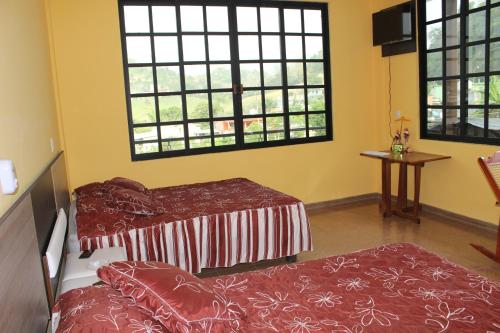 a room with two beds and two windows at El Rincón Preferido in Papantla de Olarte