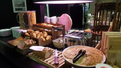 a display of different types of bread and pastries at Campanile Saint-Etienne Est- Saint-Chamond in Saint-Chamond