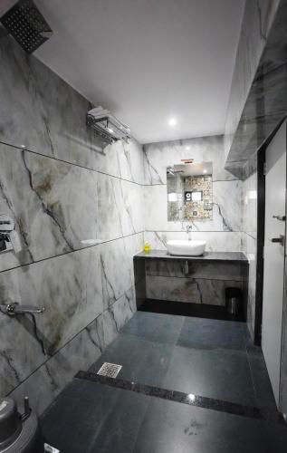 a bathroom with a sink and a mirror at MEGH INN in Navi Mumbai