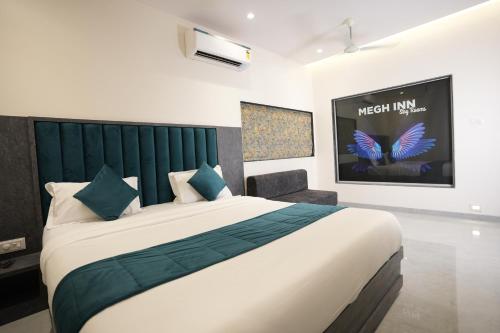 a bedroom with a large bed and a tv at MEGH INN in Navi Mumbai