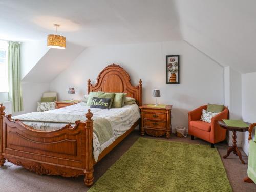 a bedroom with a wooden bed and a chair at The Mews in Bridlington
