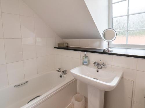 a bathroom with a sink and a tub and a mirror at The Mews in Bridlington