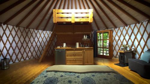 a interior of a yurt with a kitchen and a bed at Jurty i namioty w Lesie KotfaLas Glamping Świętokrzyskie-SPA in Skarżysko-Kamienna