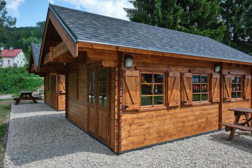 a log cabin with a pitched roof and windows at HORSKÝ PENZION U SPLAVU in Josefuv dul